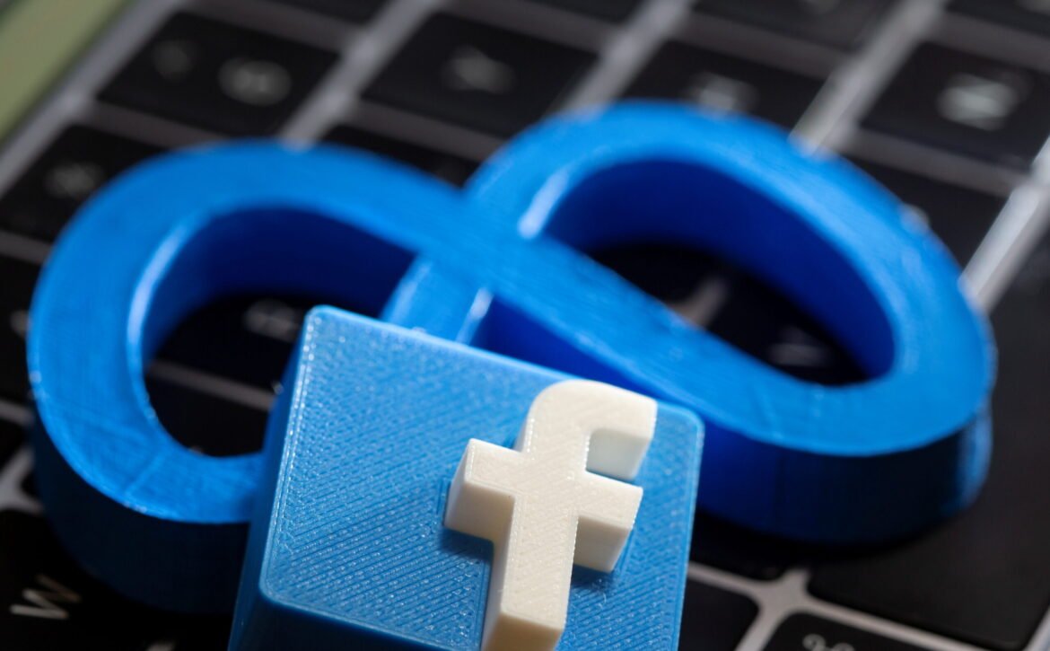 A 3D printed Facebook's new rebrand logo Meta and Facebook logo are placed on laptop keyboard in this illustration